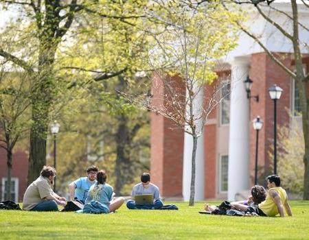 Group of students meeting with professor outside science building